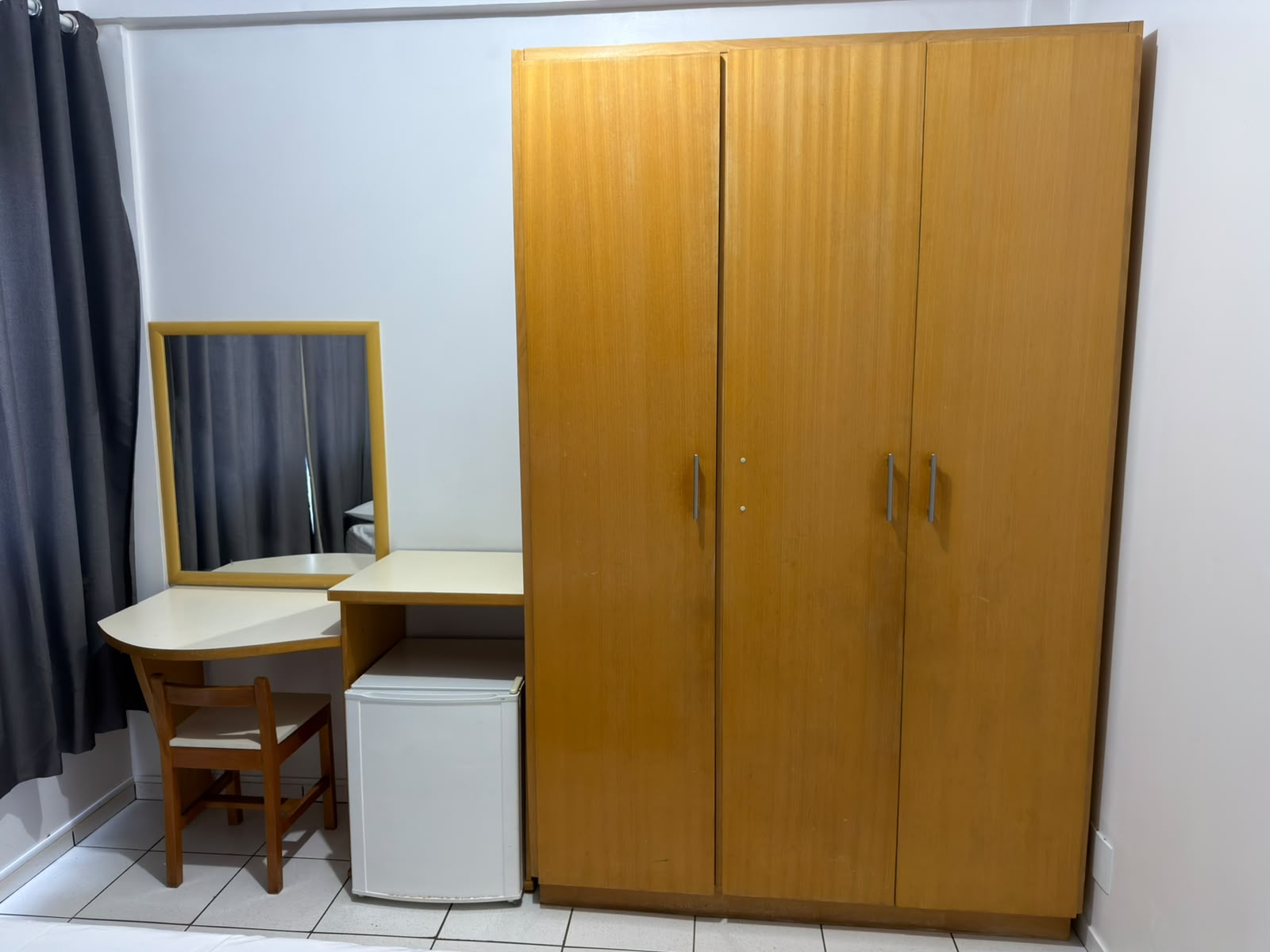 Quarto do Hotel Mello com guarda-roupa, bancada com espelho e frigobar