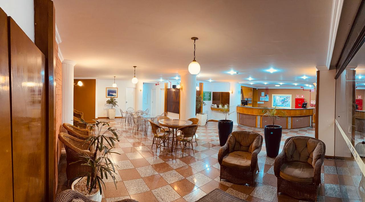 Hall amplo do Hotel Mello com poltronas e mesas